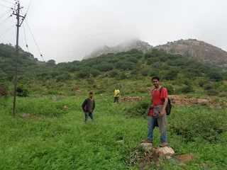 Hikers with Nidhagal betta in the background as fog engulfed it
