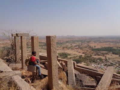 Sippy resting on the fallen pillars of an old ruined structure enroute the summit of medigeshi