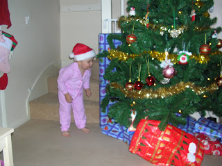 Top Ender leaning into the Christmas Tree looking at the gifts expectantly