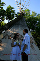 couple standing in front of tipi