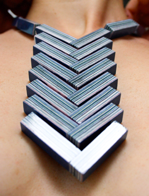 large, modern geometric necklace made of blue papers giving a striped effect