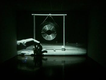 una imagen de la obra de Rodney Graham Lobbing Potatoes at a gong 1969