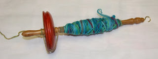 drop spindle with wool yarn