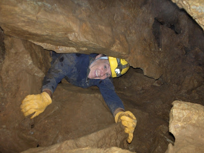 Crawling out of small Manhole cave opening Oregon Caves National Monument Oregon