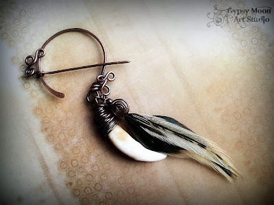 wolf tooth and feather penannular brooch