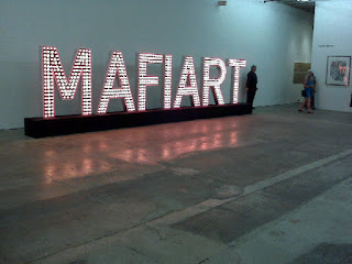 Klaus Guingand artwork: MAFIART -  Wooden and aluminum letters, red and yellow light bulbs, 26 feet x 1,47 feet x 7,22 feet