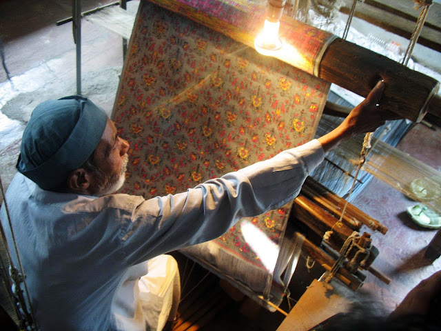 Indian weaver with tapestry