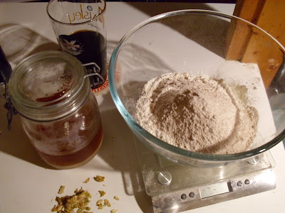 Bowl with flour, scattering of hops, yeast in a jar, beer in a glass