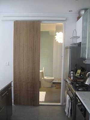Bathroom in a NYC apartment with a wood sliding barn door