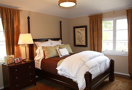 Taupe guest bedroom with a dark wood bed and matching nightstand