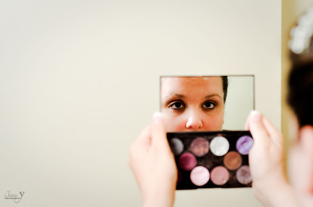 Getting ready photography of bride looking in compact mirror for her las vegas wedding