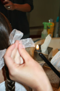 Lighter being used to seal the ends of a ribbon so it doesn't fray