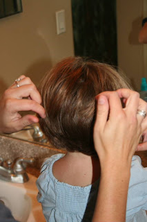 Back view of young girl's hair being styled by hand