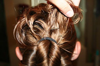Young girl's hair being styled into "Pretzel-Twist Messy Bun"