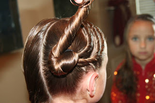 Young girl's hair being styled into "Triple Twists and Messy Buns"