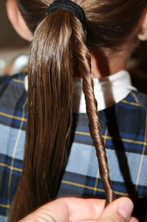 Young girl's hair being styled in to "Ponytail Of Twists" hairstyle