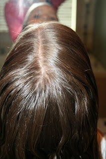 Back view of young girl's hair being styled into "Teen Hair Bun" hairstyle