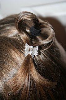 Close up view of a young girl outside modeling “Heart Pigtail” hairstyle