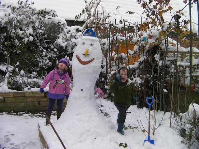 the best snowman in the world made with plant pots and plastic spades