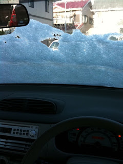 自動車のフロントガラスに雪がまだ残ってた