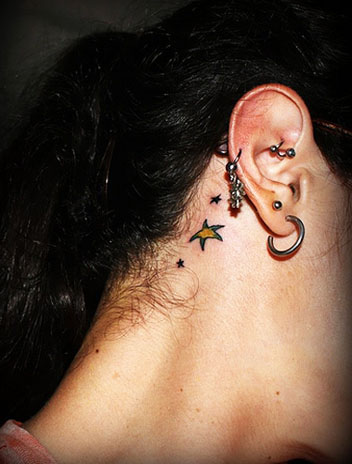 small star tattoo on hand · two small tattoo behind ear