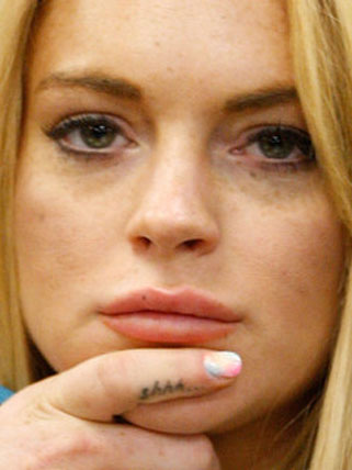 Lindsay Lohan has gotten a new tattoo and went back to her red-haired roots.