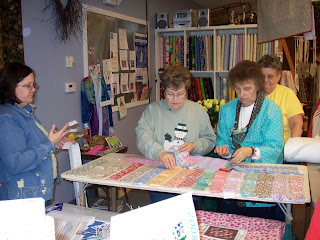 Quilters choosing their strips of fabric with Stacy's help