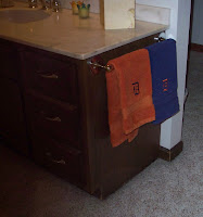 Blue and orange towels in bathroom with an old English D embroidered on them