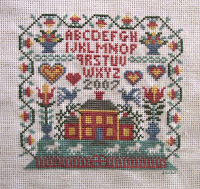 cross stitched house sampler