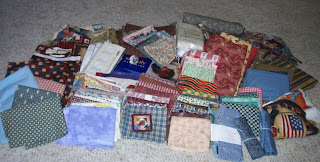 big pile of fabrics scraps, batting, book, etc won from Molly's giveaway