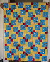 Disappearing Nine Patch quilt top using blue Snoopy fabric and assortment of yellows