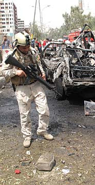 Troops examine the remnants after a bomb attack outside the Iranian Embassy