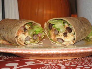 plate of wrap cut in half stuffed with chicken and various vegetables