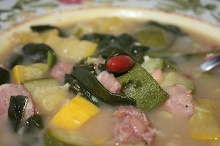 bowl of soup with sausage, beans, squash, and zucchini