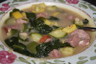 bowl of soup with sausage, beans, squash, and zucchini