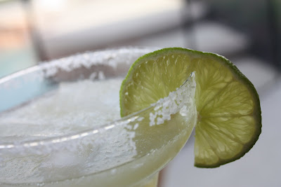 glass with margarita and salted rim served with a lime slice