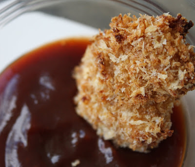 crispy chicken bite being dipped in barbecue sauce