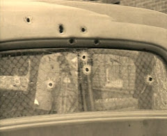 Photo showing bullet holes rear window/death car.. some of which, reportedly fired by Ted Hinton