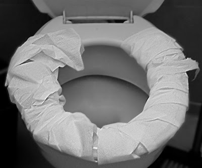 унитаз, обмотанный туалетной бумагой