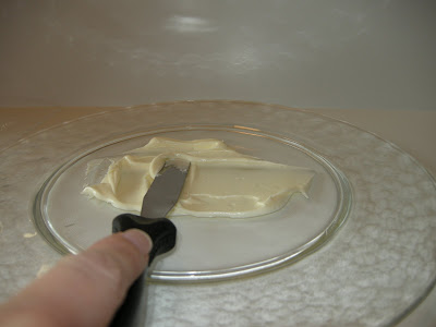 Spread cream cheese icing on plate to secure the chocolate velvet cake.