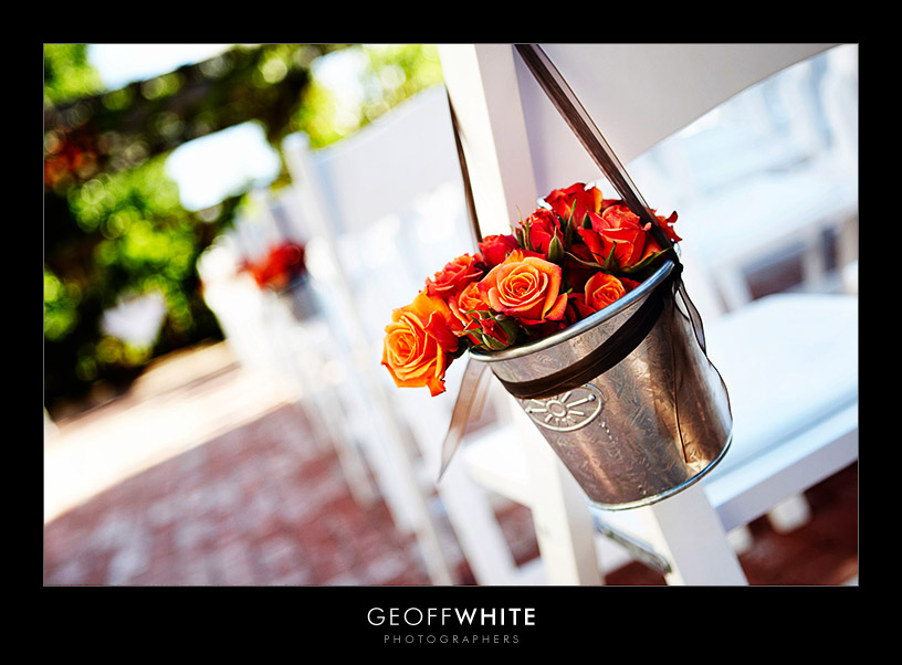 Floral filled metal pails make great pew marker for an outdoor fall wedding