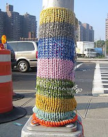 lamp post with multicolored knitted sleeve on it about two feet high