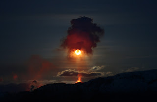 erupting volcano at night under full moon