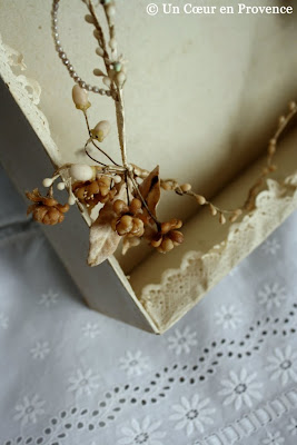 Old bridal ornaments in original box whose contour is festooned with lacy paper