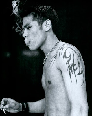 Thin tribal shoulder tattoo on smoking Asian young man asian man tattoos