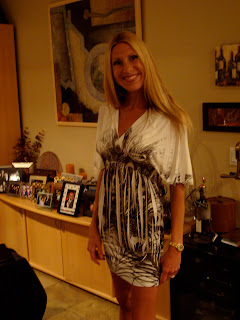 Woman standing in living room smiling in dress