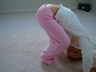 Young girl attempting downward dog yoga pose