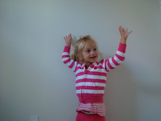 Young girl standing in front of wall with arms up - 43