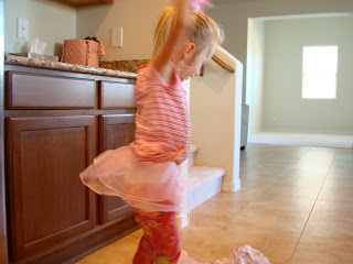 Young girl dancing in kitchen dancing in pink tutu