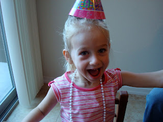Young girl smiling wearing birthday hat and white beaded necklace - 13